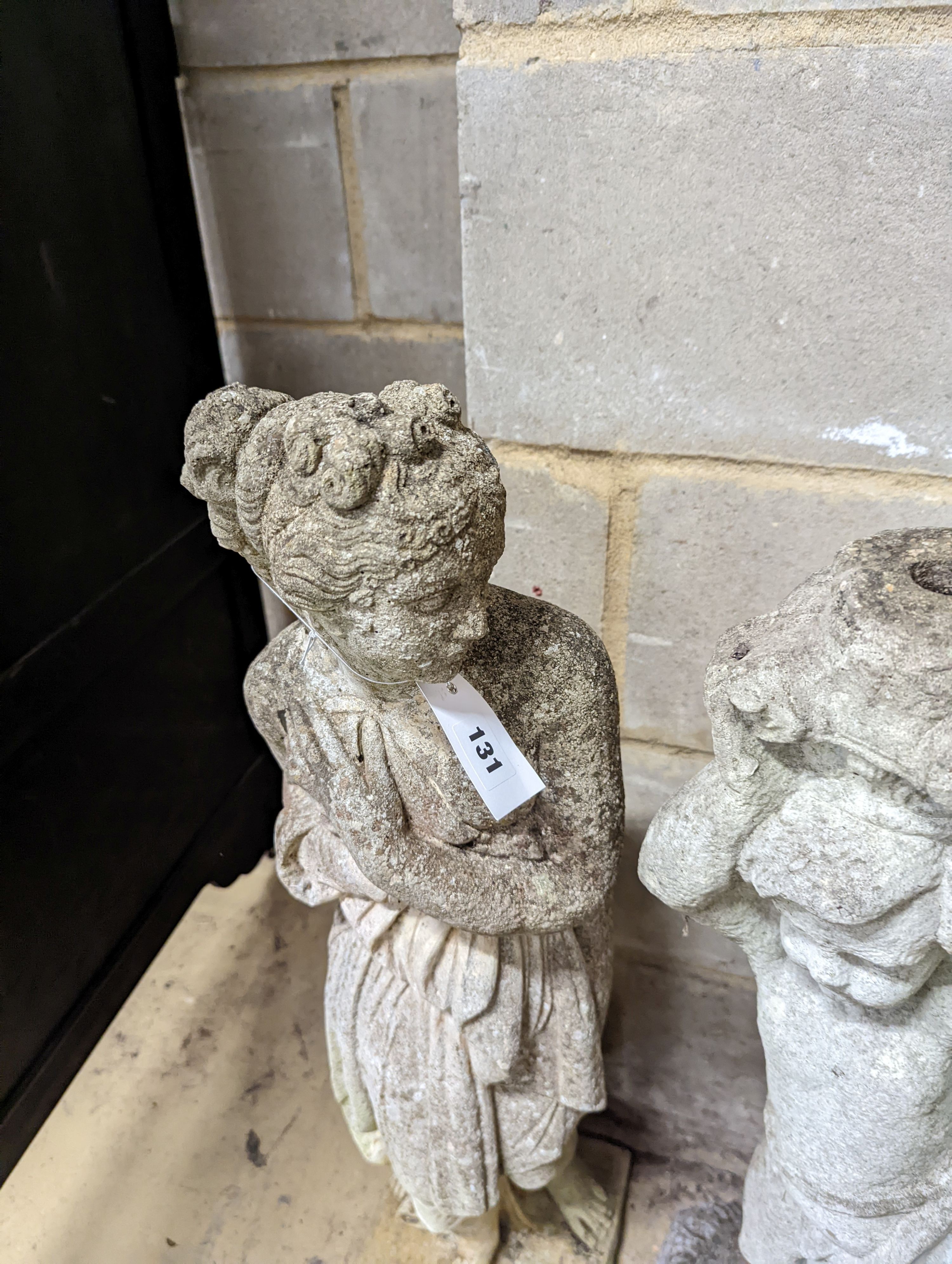 A reconstituted stone garden figure, height 80cm together with a stone figural garden column